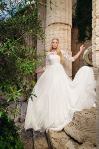 Гордо изправена булка в рокля от колекция Curvy, голям размер сватбени рокли, сред антична архитектура