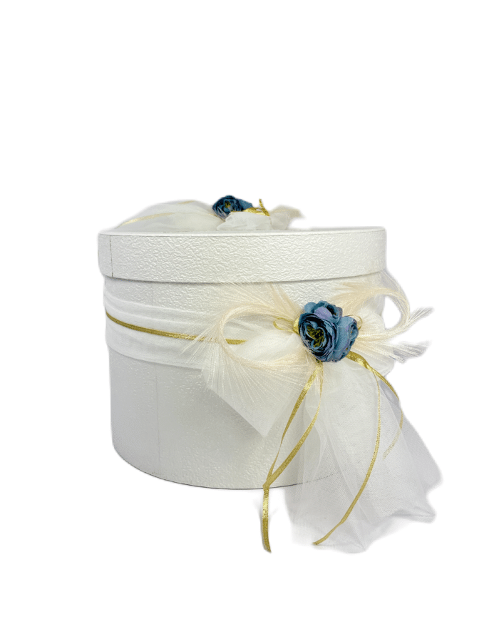 Бяла кутия за парични подаръци, украсена със сини цветя и златисти ленти, добавяща изисканост към сватбената церемония.