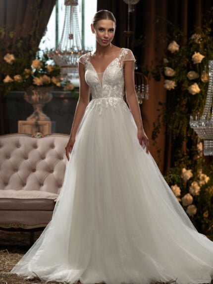 Класически сватбени рокли Нели с дантелени апликации и V-образно деколте на фон на луксозен интериор.