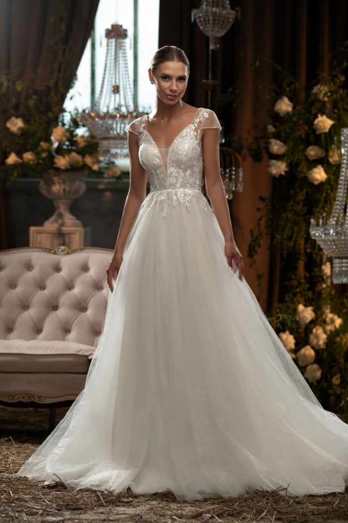 Класически сватбени рокли Нели с дантелени апликации и V-образно деколте на фон на луксозен интериор.