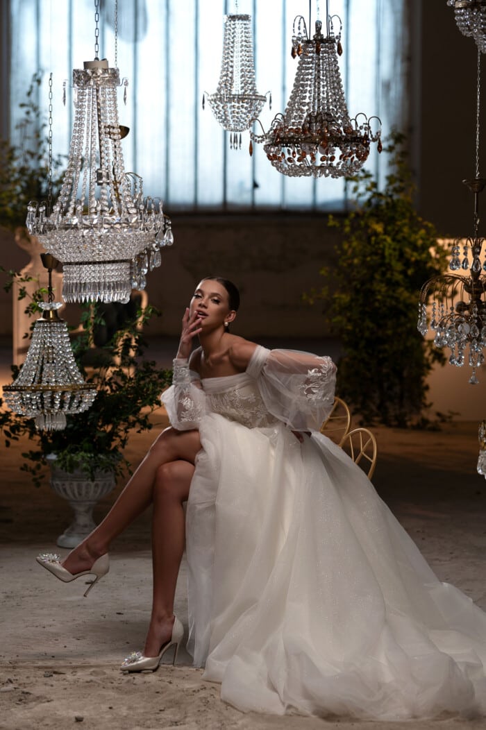 2024 Булчински дантелени рокли - модел Петра. Булка в елегантна сватбена рокля с дантела в лукзозна стая в кристални полилеи.
