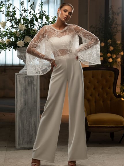 Модерна сватбена рокля с с панталони и дантелен топ и широк панталон, позиционирана в елегантна обстановка с цветя
