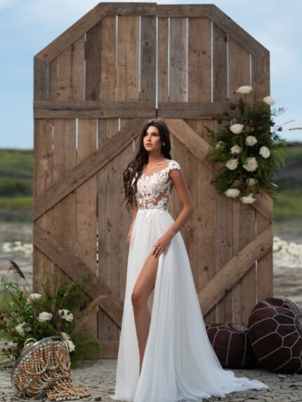 Модел позира със сватбена рокля с голяма цепка Сола с дантелен топ - елегантност и смелост в едно