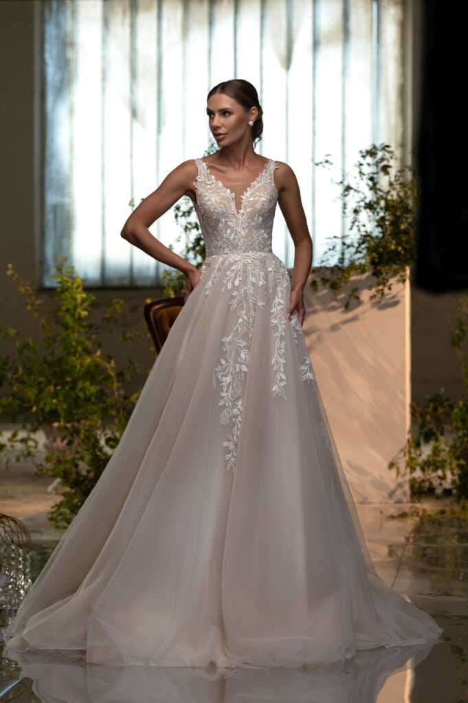 Модел с елегантна сватбена рокля с отворен гръб и богата бродерия, представена в Сватбен център myWEDDING